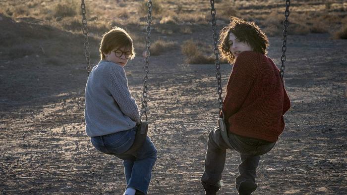 The Goldfinch Movie: Young Theo and Boris on swings, looking over their shoulders