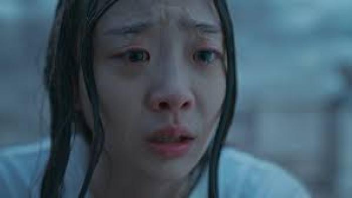 The Great Flood movie: Kim Da-mi with long black hair in white t-shirt has tears in her eyes, standing while outside in pouring rain, soaking wet