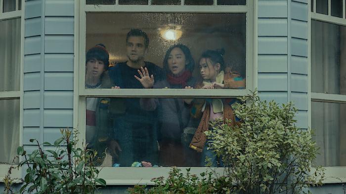The Last House: A family looks out their window in panic.