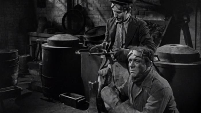 The Lavender Hill Mob: Two White men are shown working in a metal factory wearing gloves and goggles