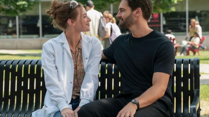 The Love Hypothesis: Lili Reinhart and Tom Bateman on a bench.