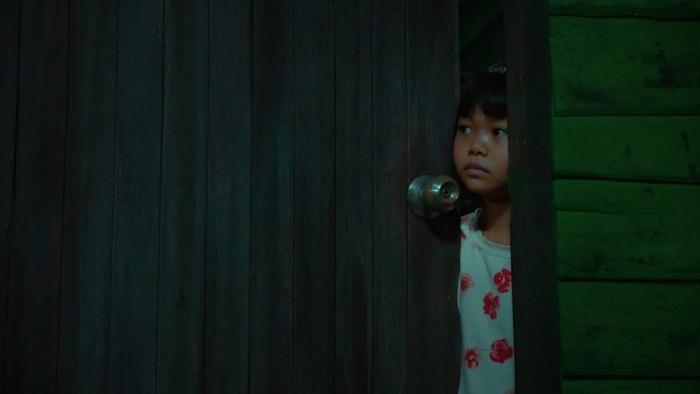The Murderer movie: Thai girl right peeks through door crack in dark room