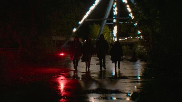 The Park: Four silhouettes of kids at night walk toward camera in a theme park.
