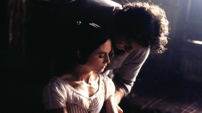 The Piano Movie: A couple embraces in a dimly lit room, sunlight casting a soft glow.