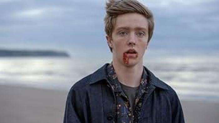 The Radleys: Harry Baxendale stands on a beach with blood dripping from his mouth and the sea in the background