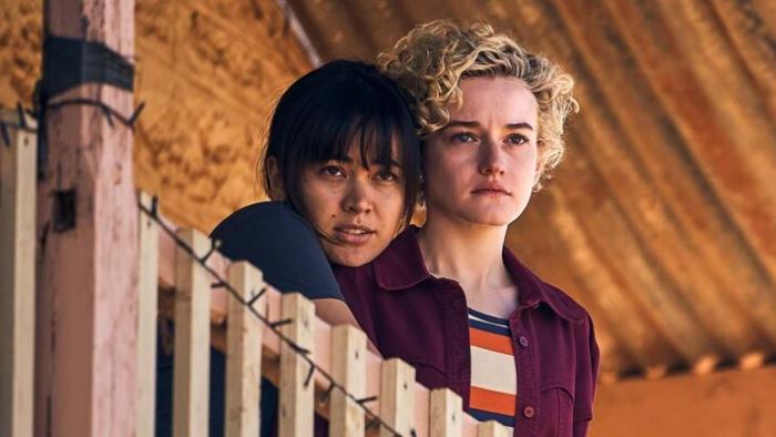 The Royal Hotel: Liv puts her arms around a concerned looking Hanna as they look out from their balcony.