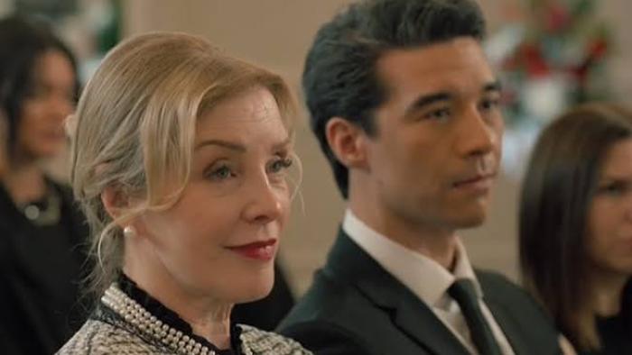 The Body in the Locker: White Woman and man in formal attire sitting attentively.