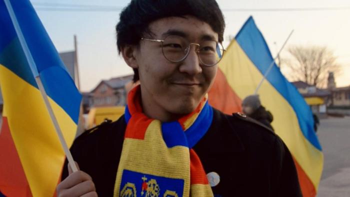 Closeup of a young man with colorful flags of Romania.