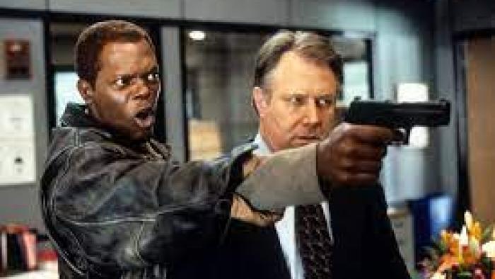 The Negotiator: Two men aim a gun at an unseen person