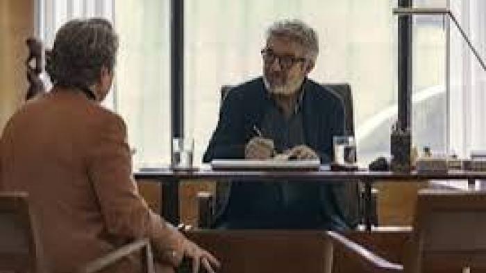 Therapy Done Right Movie: Two men talking across a desk in a well-lit office.