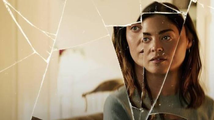 The Secret Woman: Woman's reflection in cracked mirror, thoughtful expression.