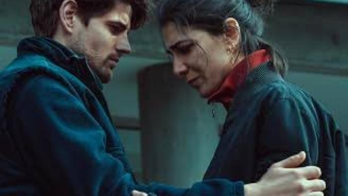 The Truthers Movie: A couple in a tender embrace, looking worried outdoors.