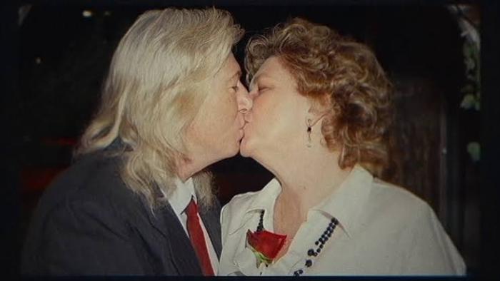 The Widower: A couple kissing, with one wearing a suit and the other a white blouse.