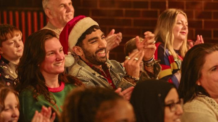 Tinsel Town: A smiling audience clap along to a Christmas pantomime, just out of shot