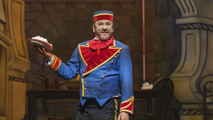 Tinsel Town: Kiefer Sutherland stands on stage dressed as the character Buttons and holds up a pie