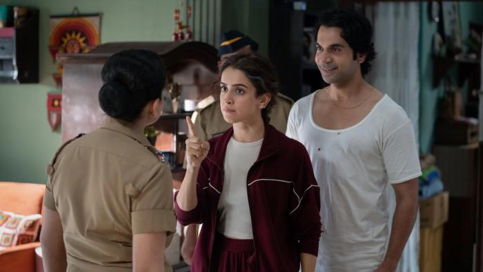 Toaster: An Indian husband and wife talking with a female police inspector in a living room setting