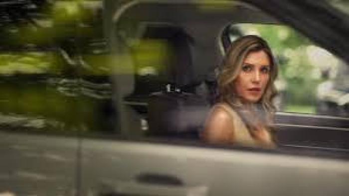 To Catch a Cheater: Woman with long hair sitting in a car, looking out the window.