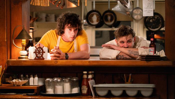 Tony movie: Dominic Sessa is young Anthony Bourdain, looking out the serving window with co-worker Sal (Leo Woodall)