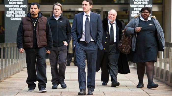 Tower Heist Movie: A group of four men and one woman walk on a paved path