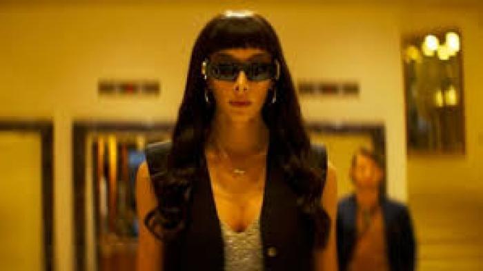 Transmitzvah: A woman with sunglasses on inside walks