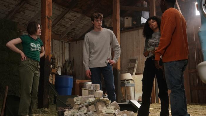 Trap House Movie: Deni, Cody, Yvonna, and Kyle stand around a huge pile of money, seriously discussing what to do next