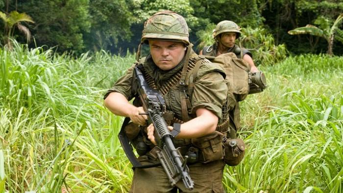 Tropic Thunder Movie: Jack Black and Ben Stiller stalk through a jungle in army gear holding machine guns