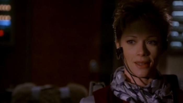 Turbulence: Lauren Holly sits in plane cockpit wearing flight attendants’ uniform and a microphone in front of her face