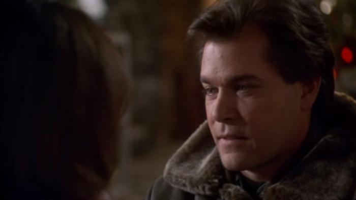 Turbulence: Ray Liotta looks to left wearing winter coat with a furry collar with christmas lights in the background