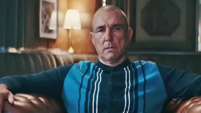 Untold UK -- Vinnie Jones: Vinnie Jones in striped sweater sits on a leather sofa in a cozy, dimly lit room
