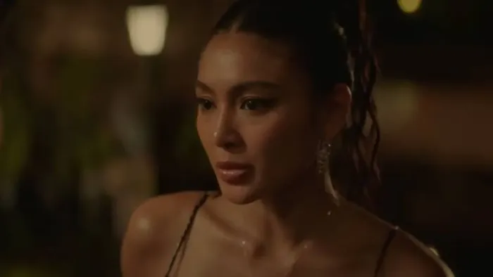 Uninvited movie: Filipino woman with hair up in black dress looks seriously ahead while at a fancy party