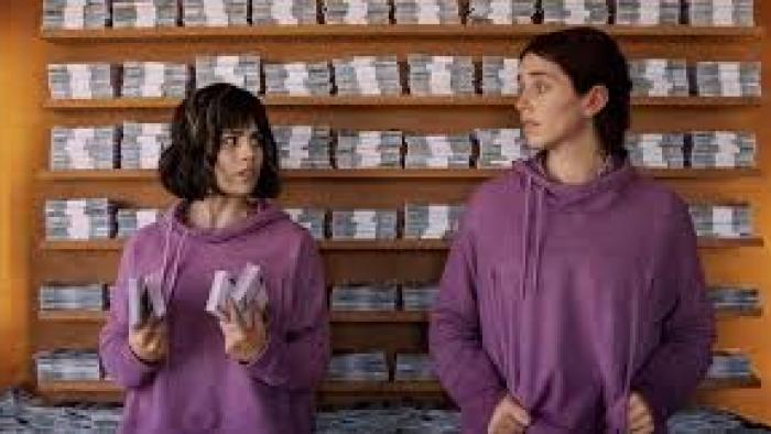 (Un)lucky Sisters: two women against a wall of money