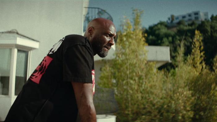 Untold: The Death & Life of Lamar Odom movie: Lamar Odom leans on a porch railing outside of his home