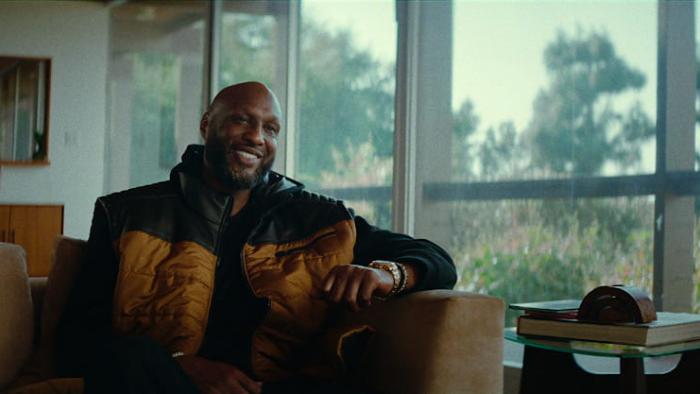 Untold: The Death & Life of Lamar Odom movie: Lamar Odom sits on a couch inside of his home