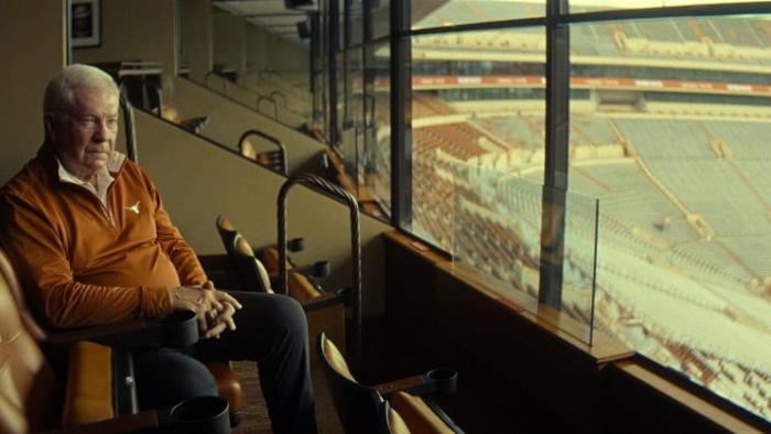 Untold: The Testimony of Vince Young movie: Mack Brown sits in a seat in a press box at the University of Texas