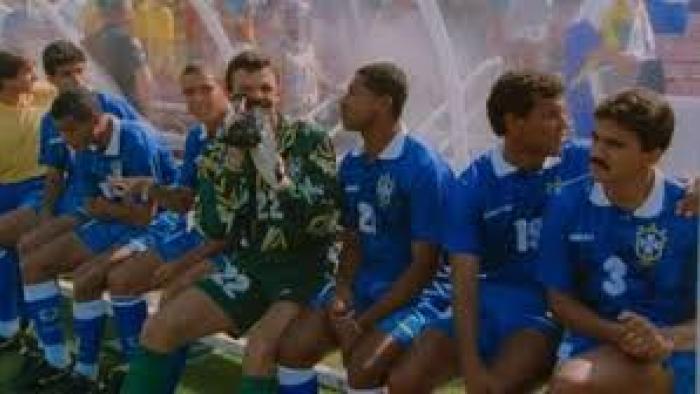 USA 94: Brazil's Return to Glory movie: Soccer team sitting on bench under mist spray, wearing blue uniforms.