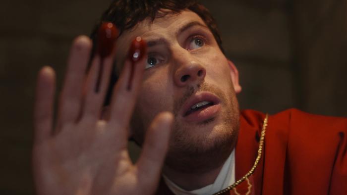 Wake Up Dead Man movie: A Knives Out Mystery: Josh O'Connor is a priest holding up his fingers, with blood on the tips