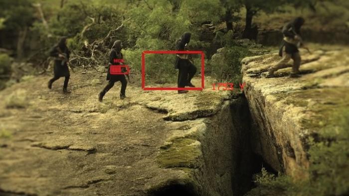 Warhorse One: Taliban insurgents cross gap holding rifles viewed through binoculars.