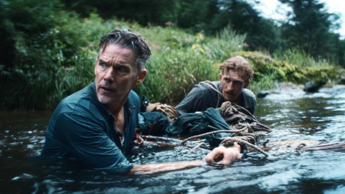 The Weight Movie: Murphy and Rankin maneuver a makeshift raft as they cross a river, in the water up to their chests