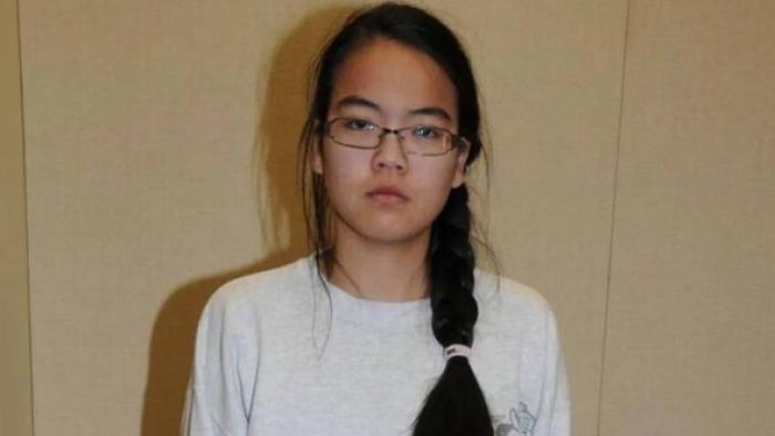 What Jennifer Did movie: Asian American woman in white shirt, long black hair, and glasses stares solemnly ahead 