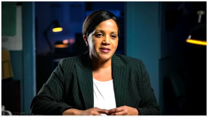 What Jennifer Did movie: Black woman in black sports coat sits and talks with interviewer in office