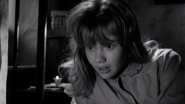 Whistle Down the Wind: A young blond girl, sitting on a bed in night dress, leans forward