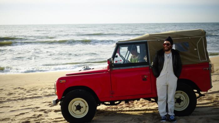 Who Invited Charlie? Movie: On the beach, Charlie stands outside a Jeep while Max sits inside