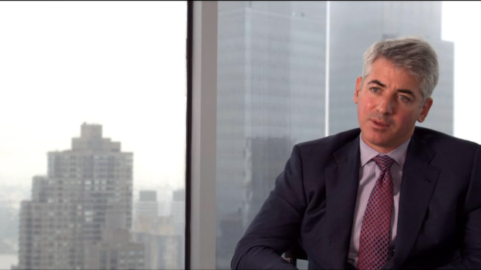 Inside Job: A White man sits in front of a high-up view of skyscrapers as he's interviewed