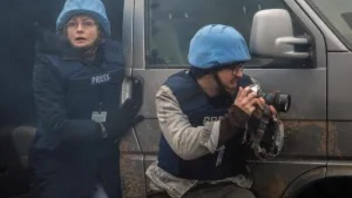 Words of War: Maxine Peake wears a protective army helmet as she steps out of a vehicle, a fellow member of the press holding a camera in front of her