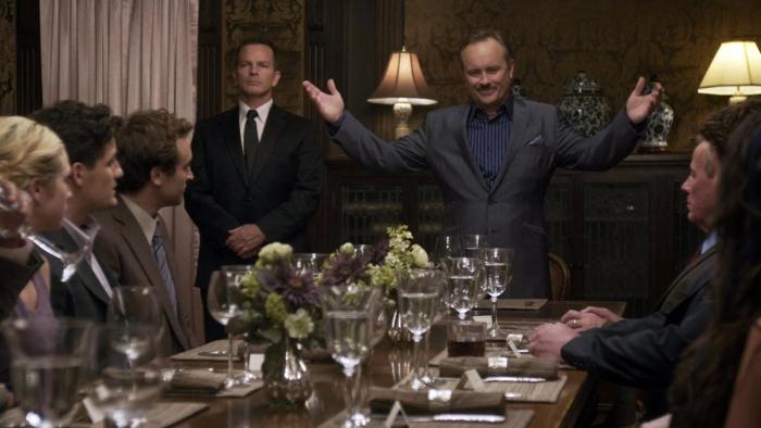 Would You Rather: Dining room scene with a man standing and speaking to seated guests