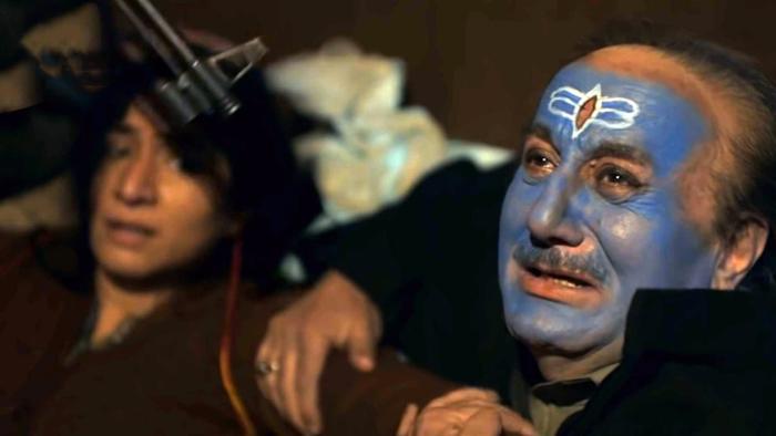 The Kashmir Files: A man with blue face paint has a gun pointed at him while a woman looks on.