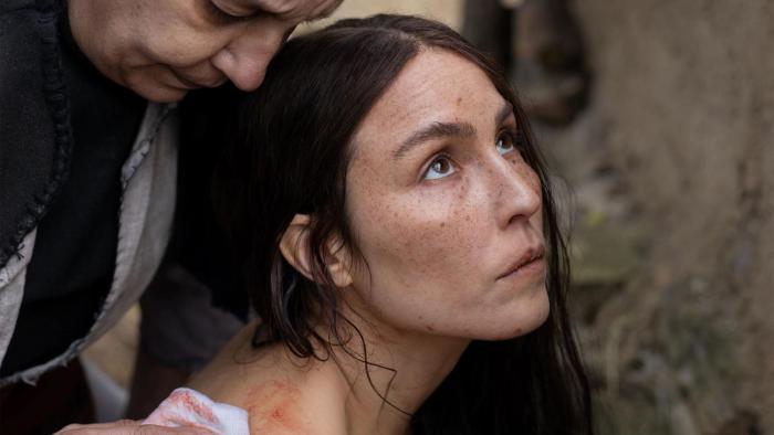 You Won't Be Alone: Close-up of Noomi Rapace looking up to sky with older woman behind her