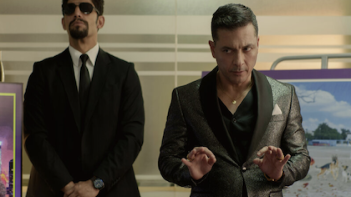90 Minutes TV show screenshot 2: A body guard stands by Yuriel Santana during a presentation. 