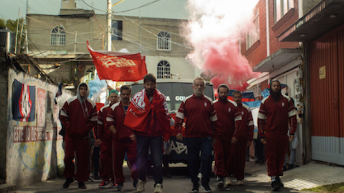 90 Minutes TV show screenshot 2: Las Navajas walk together in red uniform with red smoke behind them.