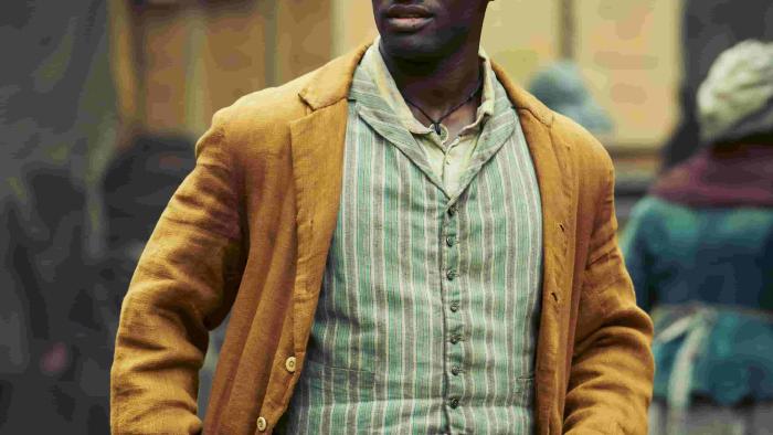 Stephen Graham and Malachi Kirby throw punches at each other in a boxing ring. Graham wears red pants, while Kirby wears brown.